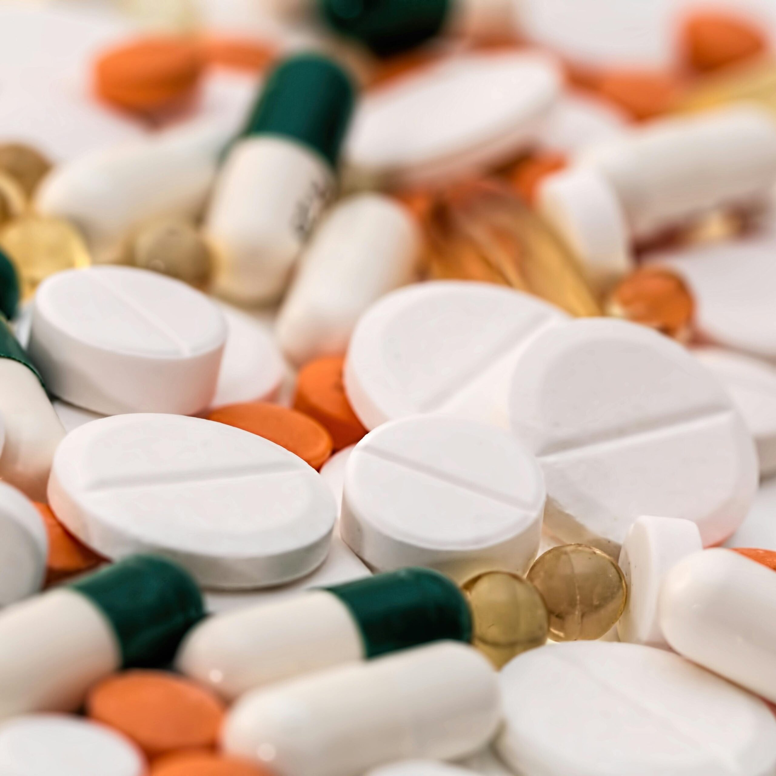 Close-up of various pills and capsules in different colors and sizes, ideal for healthcare-related content.